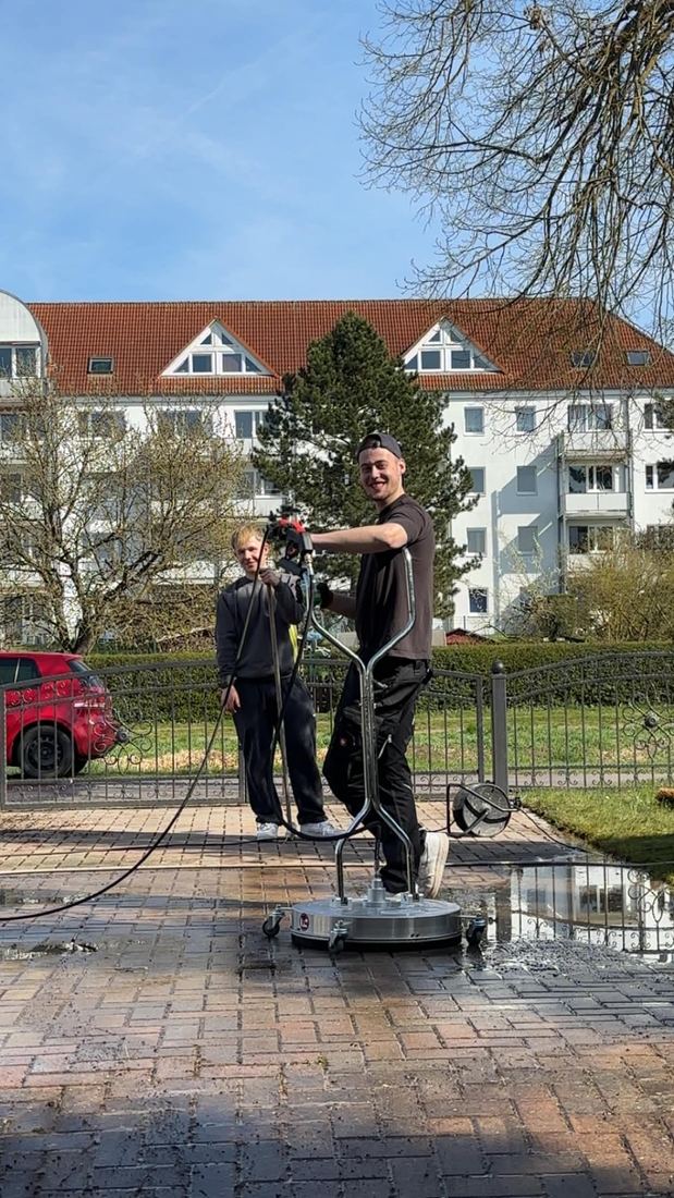 Zwei ONF-Mitarbeiter mit Flächenreiniger auf frisch gereinigtem Pflaster